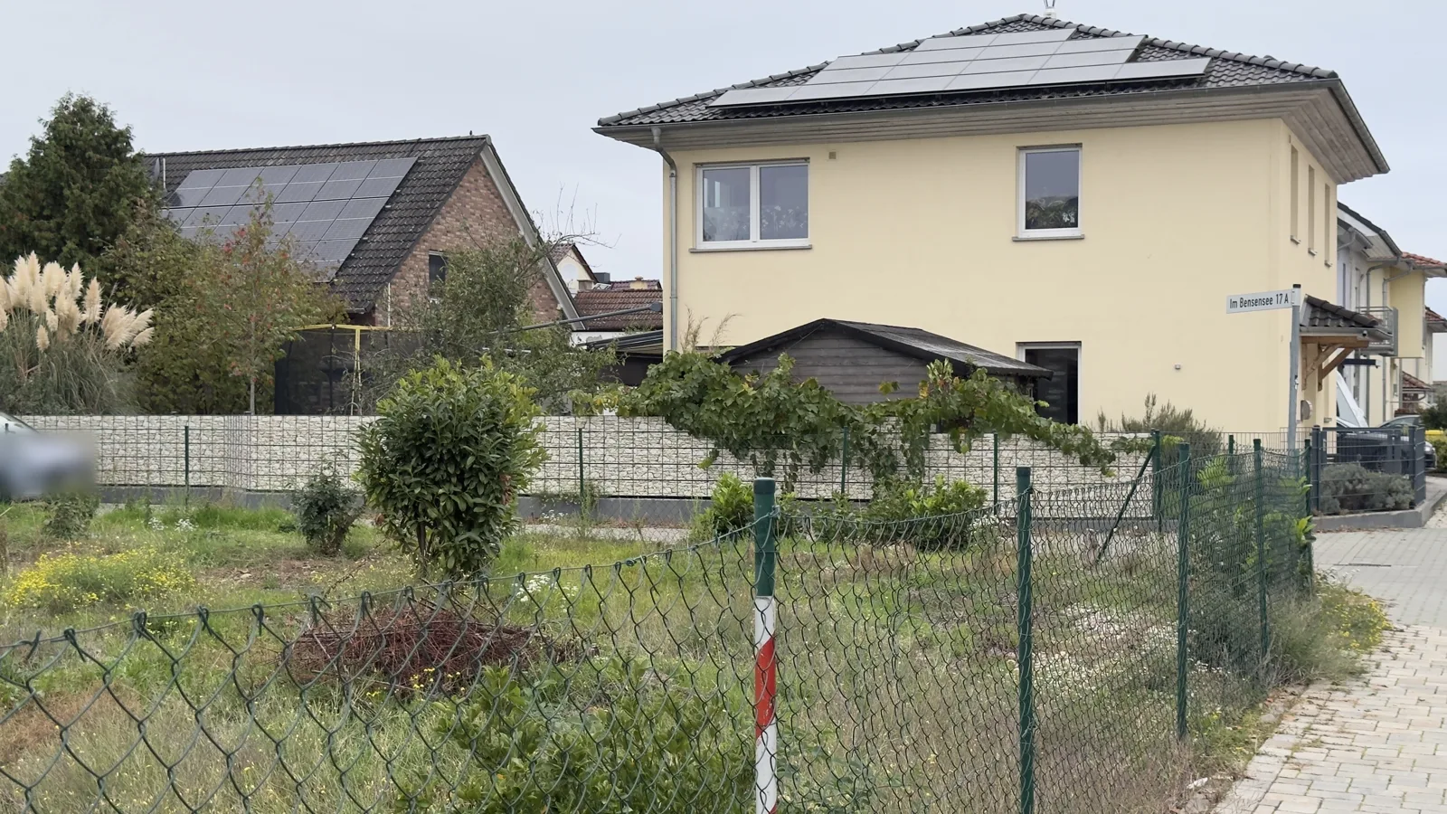 Ruhige Anliegerstraße entlang des Zauns